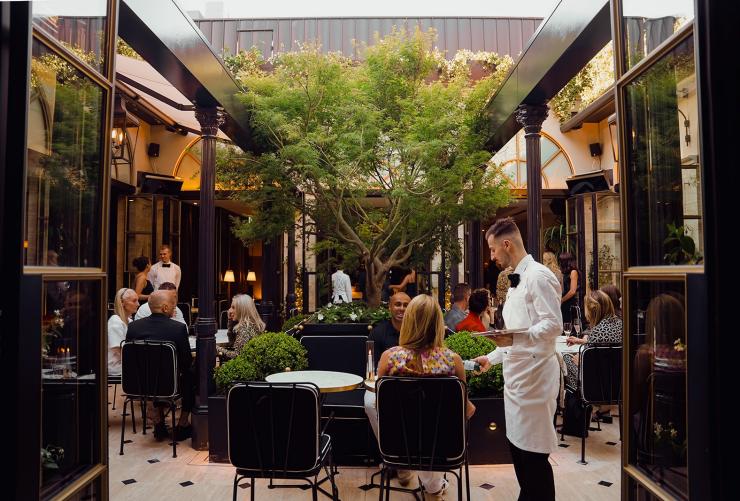 La Terasse - the rooftop terrace, a waiter serving guests. © Liana Hardy Photography