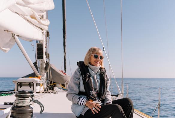 A happy guest sitting on the helm on Brindabella © Arne Studio