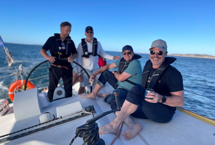 Happy guests on a group charter with the captain at the helm © Brindabella Sailing