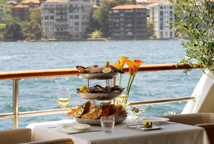 A three tier  seafood platter on a dining table overlooking Sydney Harbour © Jason Loucas