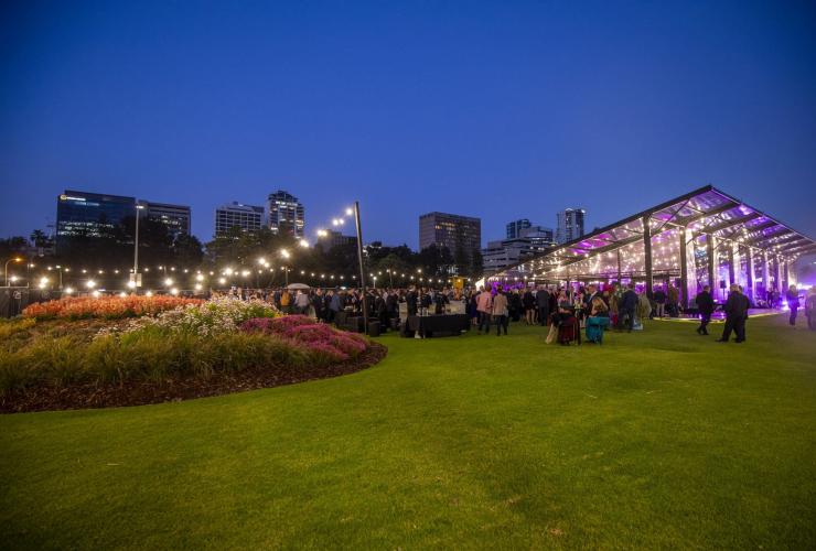 A night view of The Kingsman and lawned area against Perth’s city skyline. © The Kingsman