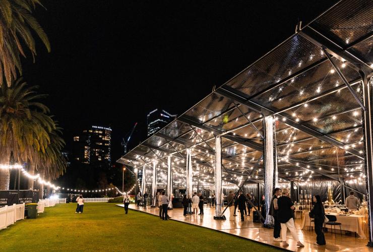 The glass encased venue, The Kingsman set up for an event with people on the wooden floor and lawn. © The Kingsman 