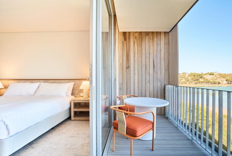 A view of part of the interior of a poolhouse room and the balcony overlooking the lake. © Shot By Thom