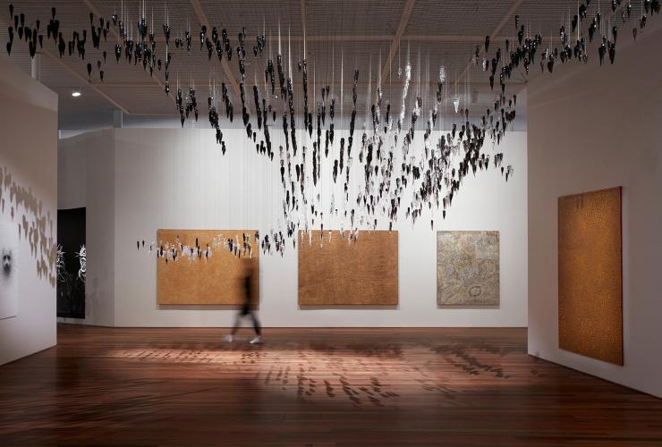 Installation view of the Yiribana Gallery featuring Gallery featuring (from left) YukultjiNapangati 'Untitled' 2005, DoreenReid Nakamarra 'Untitled' 2007,Bobby West Tjupurrula 'Tingari sites around Kiwirrkura' 2015 and RonnieTjampitjinpa 'Tingari fire dreaming at Willinkkarra' 2008, and (top) Yhonnie Scarce 'Death zephyr' 2017 © Ken Leanfore 