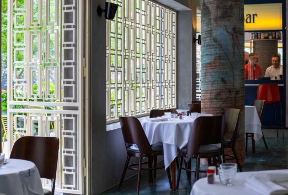 White tablecloths, sunlit windows and raw concrete pillars set the scene in a restaurant © Roma Ristorante