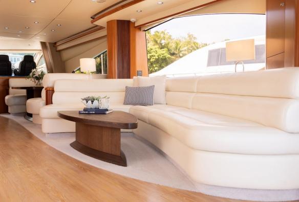 A plush white lounge and wood panelling set the scene inside a luxury yacht © Sailing Whitsundays