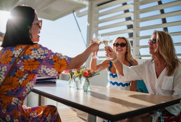 A close up taken inside a beach cabana with guests toasting glasses of wine © Tangalooma Island Resort