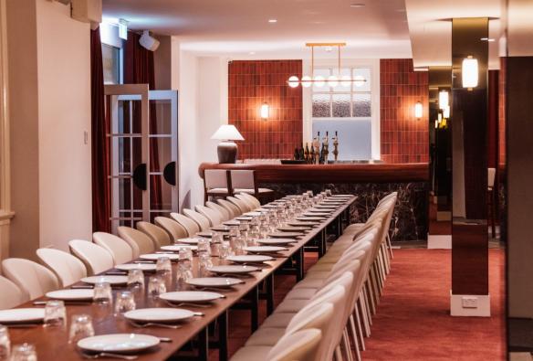A long table with many place settings is set up neatly in a well decorated room. © Hotel Terminus