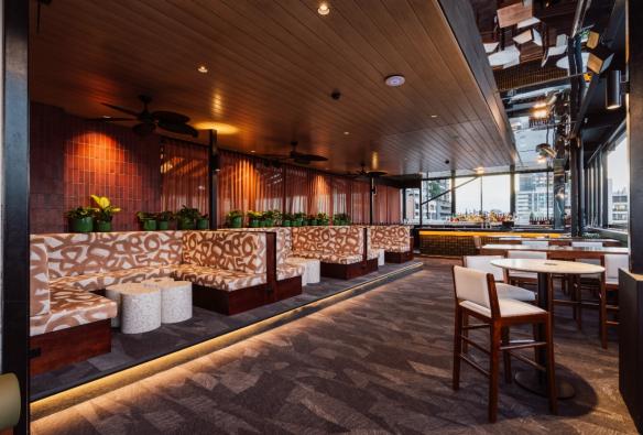 Plush booth seating and bar tables sit inside a rooftop venue. © Hotel Terminus
