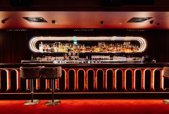 Red carpets, dim lighting and low ceilings create ambiance at a bar. © Hotel Terminus