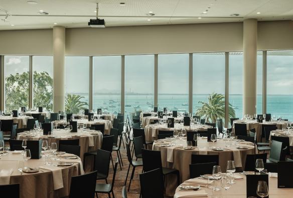 An event room with banquet-style table settings sits in a room overlooking a pretty bay. © Nic Stephens / Nyaal Banyul Geelong Convention and Event Centre