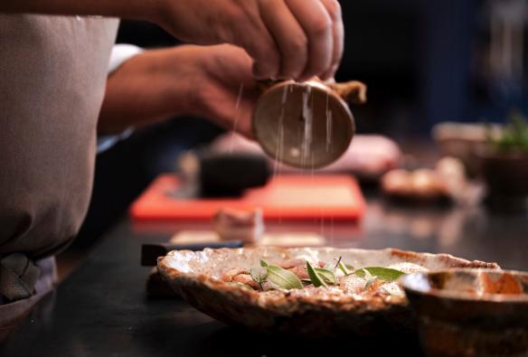 Close up of a chef seasoning a dish, ready to serve. © Andrew Wilson Photography